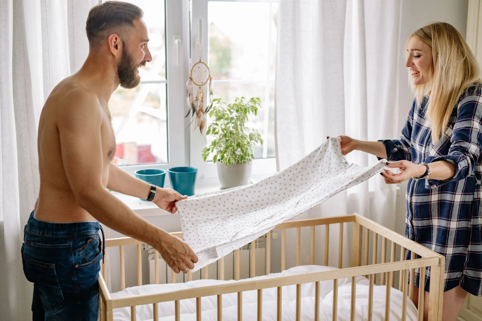 A couple preparing a cot in a bedroom