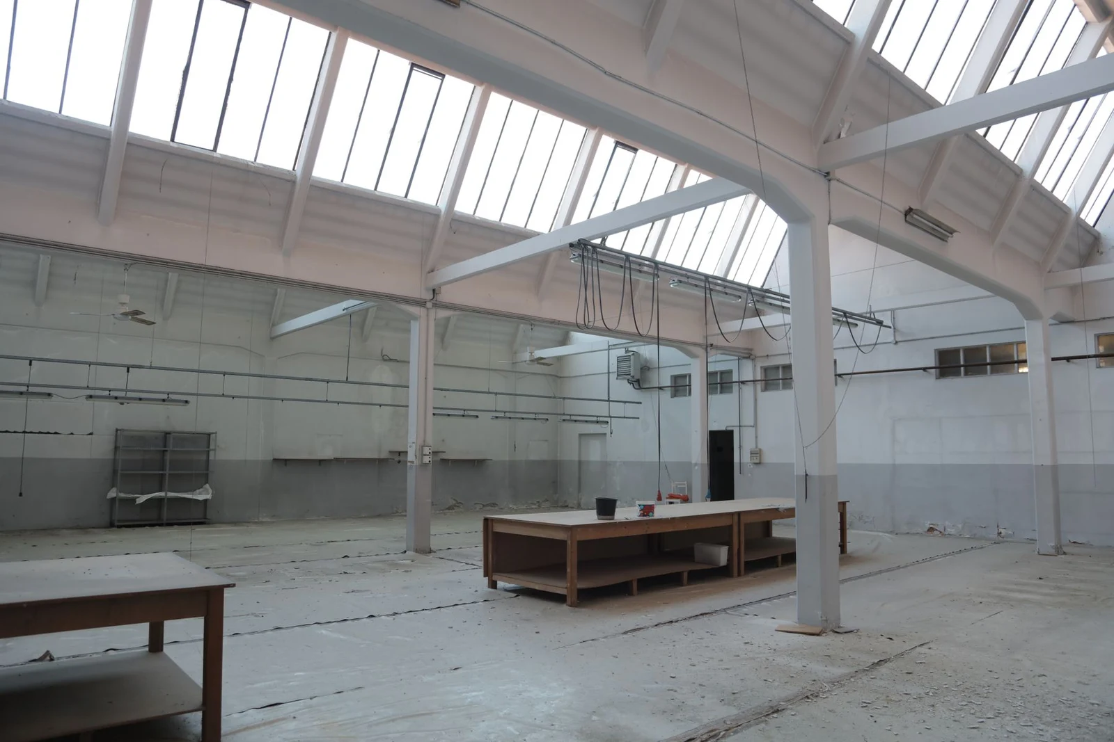 An empty industrial interior with columns and skylights